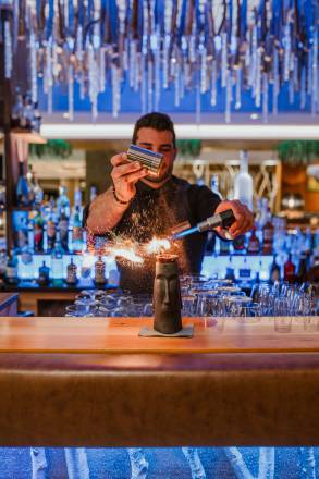 Barkeeper mixt einen Drink mit Feuer