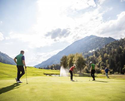 Golfer stehen auf Golfplatz in den Alpen